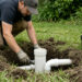 Technician repairing PVC septic riser and pipe connections in a residential yard — Solid State Septic