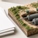 Scale model of a residential septic tank and gravel bed with soil cross-section on a design desk — Solid State Septic