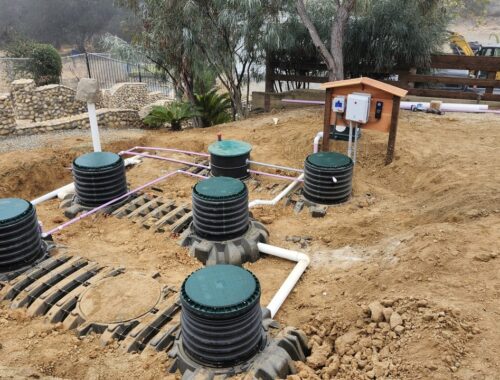 Residential OWTS installation with green risers, PVC manifold piping, and control panel enclosure — Solid State Septic