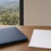 Wooden desk with navy binder and blank documents beside a window overlooking San Diego County hills — Solid State Septic