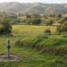 Rural green hillside with septic mound and monitoring pipe under clear San Diego County sky — Solid State Septic