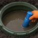 Technician servicing an open septic tank